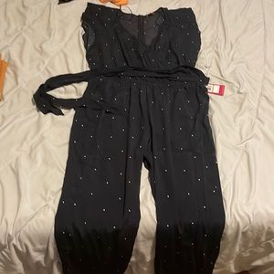 Navy polka dot jumpsuit with capped sleeves and waist tie